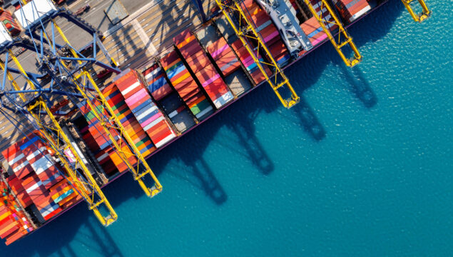 Aerial view of cargo ship and cargo container in harbor.